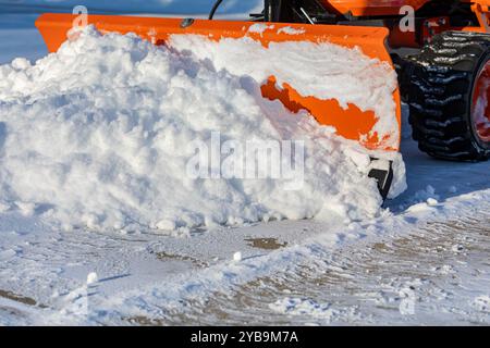 Schneeräumung von der Auffahrt mit Schneepflug. Winterwettersicherheit, Hauspflege und Schneesturm-Konzept. Stockfoto