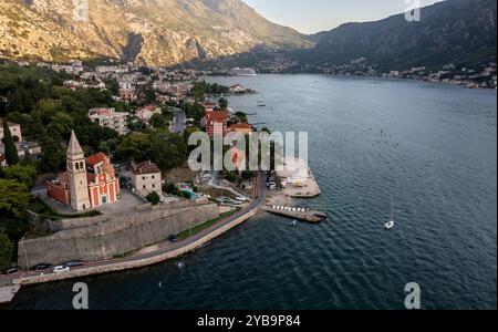 Blick aus der Vogelperspektive auf die alte Kirche in der Bucht von Kotor mit Hafen im Hintergrund Stockfoto