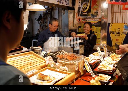 Ein Anbieter, der geröstete Aale und andere geröstete Meeresfrüchte auf dem Nishiki-Markt verkauft. Kyoto, Japan Stockfoto