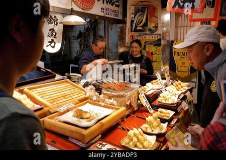 Ein Anbieter, der geröstete Aale und andere geröstete Meeresfrüchte auf dem Nishiki-Markt verkauft. Kyoto, Japan Stockfoto