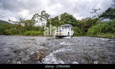 Toyota Geländewagen mit Dachzelt fährt durch einen breiten Fluss im Regenwald, Provinz Alajuela, Costa Rica, Mittelamerika Stockfoto