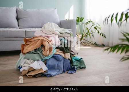 Stapel von achtlos verstreut Kleidung auf dem Boden. Stockfoto