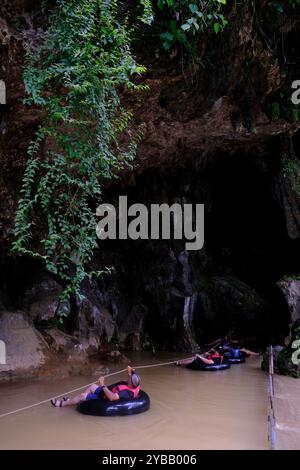 Touristen folgen einem Seilschlauch in die Tham Nam Wasserhöhle. Vang Vieng, Laos Stockfoto