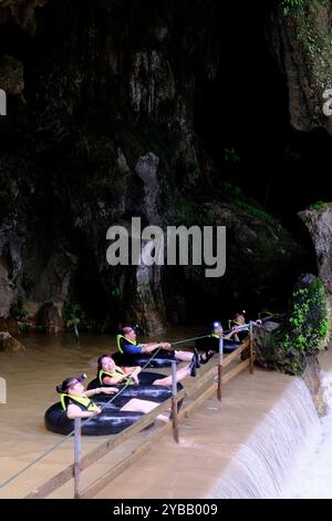 Touristen folgen einem Seilschlauch in die Tham Nam Wasserhöhle. Vang Vieng, Laos Stockfoto