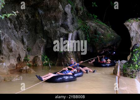 Touristen folgen einem Seilschlauch in die Tham Nam Wasserhöhle. Vang Vieng, Laos Stockfoto