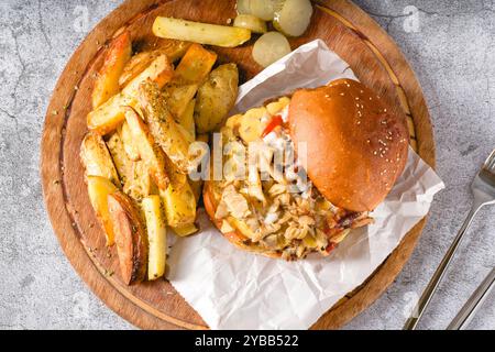 Hühnchenburger mit Pilzen auf einem hölzernen Schneidebrett Stockfoto