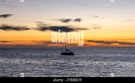 Silhouette einer Segelyacht auf dem Meer zur goldenen Stunde. Ein Segelurlaub, Yachthintergrund. Stockfoto