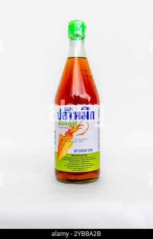 Lefkada, Griechenland- 10.04.2024. Eine Flasche Tintenfisch, echte Fischsoße mit dem Etikett in Thai. Isoliert auf weißem Hintergrund. Stockfoto
