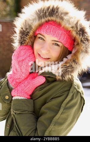 Lächelnde Teenager-Mädchen tragen Kapuzen Parka im freien Stockfoto