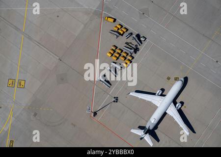 Blick von oben Flugzeug- und Gepäckwagen auf sonnigem Flughafengelände Stockfoto