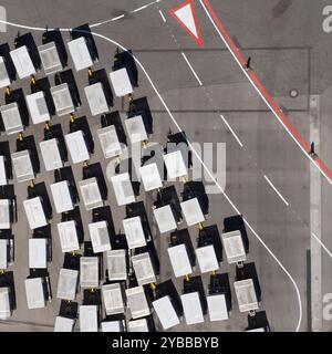 Blick von oben auf den Gepäckwagen auf den sonnigen Flughafenparkplatz Stockfoto