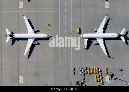 Blick von oben Flugzeuge, die von Angesicht zu Angesicht auf sonnigem Flughafenparkplatz geparkt sind Stockfoto
