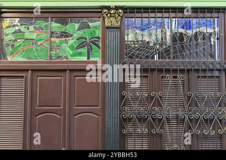 804 Buntglas-Heckleuchten, dicke Holztüren, kunstvoller schmiedeeiserner Grill und Fensterläden an geschlossenen Fenstern, Haus in der Altstadt. Havanna-Kuba Stockfoto