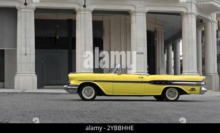 820 Gelb mit schwarzer Zierleiste amerikanischer Oldtimer - Pontiac von 1957 - in der Calle San Rafael Street neben dem Manzana de Gomez Block stationiert. Havanna-Kuba. Stockfoto