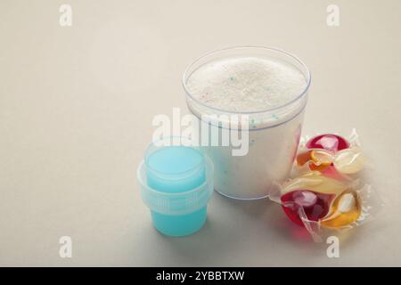 Waschmittel mit Waschpulver und Kapseln auf grauem Hintergrund. Draufsicht Stockfoto