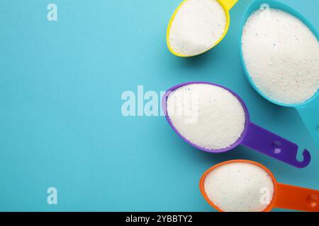 Messlöffel mit Waschpulver auf blauem Hintergrund. Draufsicht Stockfoto