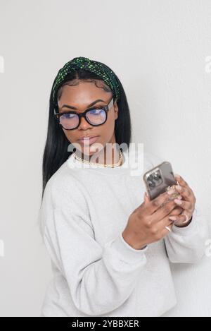 Frau, die ein Handy hält und zurückblickt Stockfoto
