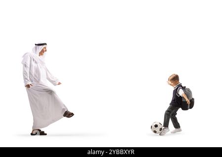 Arabischer Mann in traditionellem Gewand, der mit einem Jungen auf weißem Hintergrund Fußball spielt Stockfoto