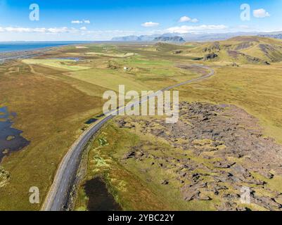 Aus der Vogelperspektive auf die Straße zum Kap Dyrholaey, Lavaformationen und Wiesen, Südküste, Island Stockfoto