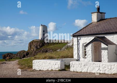 Leuchtturm Tŵr Mawr (was auf Walisisch „großer Turm“ bedeutet) und Pilotenhütten auf Ynys Llanddwyn in Anglesey, Wales Stockfoto
