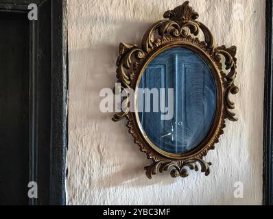 Vintage-Charme: Gerahmter grauer Schrank, Kreisverzierte Spiegel im traditionellen mazedonischen Haus. Stockfoto