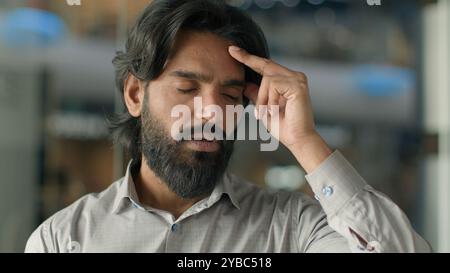 Nahaufnahme frustriert müde gestresster indischer Geschäftsmann männlicher Geschäftsmann Büroangestellter Kopfschmerzen leiden Spannung starke Migräne finanziell Stockfoto