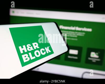 Mobiltelefon mit Logo der amerikanischen Steuervorbereitung HR Block Inc. Auf dem Bildschirm vor der Website. Fokussieren Sie sich auf die linke Mitte des Telefondisplays. Stockfoto