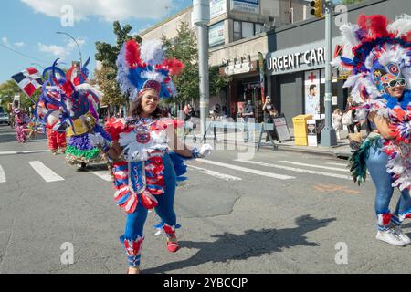 Frauen in bunten Kostümen marschieren und tanzen bei der Dominican Day Parade 2024 in Jackson Heights, Queens, New York. Stockfoto