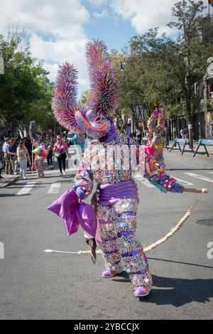 Ein Mann in einem sehr bunten Kostüm und hält Seilmärsche bei der Dominican Day Parade in Jackson Heights, Queens, New York. Stockfoto