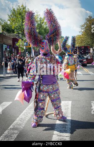 Ein Mann in einem sehr bunten Kostüm und hält Seilmärsche bei der Dominican Day Parade in Jackson Heights, Queens, New York. Stockfoto