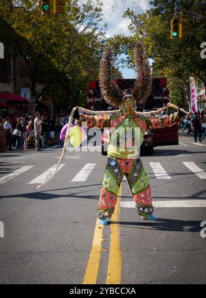 Ein Mann in einem sehr farbenfrohen Kostüm und hält einen Seilmarsch in der Dominican Day Parade in Jackson Heights, Queens, New York. Stockfoto