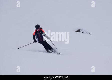 Junge Skirennläuferin im Action-Skifahren in einem europäischen Skigebiet. Seitenansicht des Skifahrers, der im Winterresort, den drei Tälern, Frankreich, abfährt. Stockfoto