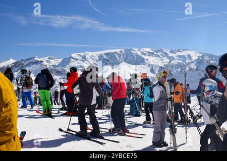 Meribel, Frankreich - 13. März 2024: Top der Skigebiete Meribel und Courchevel, drei Täler. Skifahrer und Snowboarder auf dem Gipfel des Saulire Berges. Stockfoto