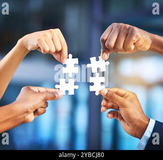 Hände, Unternehmen und Menschen mit Rätsel im Büro für Problemlösung, Zusammenarbeit und kreative Integration. Personal, Puzzle und Teambuilding mit Stockfoto