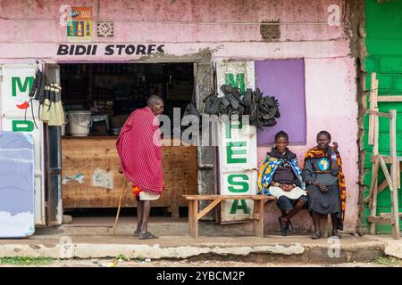 Mann in traditioneller Masai-Tracht und zwei Frauen vor einem Laden, Kenia, Afrika Stockfoto