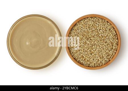 Tahini-Sauce im Glasgefäß und Sesamsamen in Holzschale auf weißem Hintergrund Stockfoto