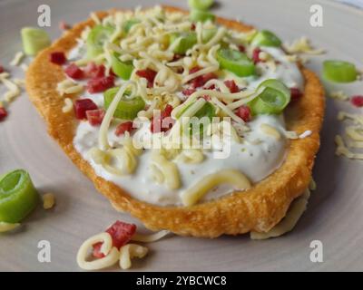 Ungarische Langos mit Knoblauchcreme, Speck, Frühlingszwiebeln und Käse Stockfoto