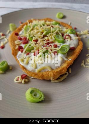Ungarische Langos mit Knoblauchcreme, Speck, Frühlingszwiebeln und Käse Stockfoto