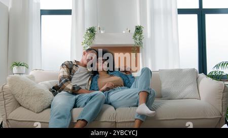Afroamerikaner Ehepartner Paar Mann Frau Mädchen Kerl auf Sofa Couch zu Hause eigene Wohnung reden über Familienangelegenheiten Plan lächelnd lachen Stockfoto