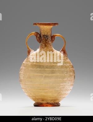 Amphoriskos, 1. Jahrhundert n. Chr. zusätzliche Informationen: Freigeblasene Amphoriskos aus durchscheinendem bernsteinfarbenem Glas, Hals, Rand und Fuß wurden durch heiße Manipulationen mit Werkzeugen geformt. Squat und kugelförmiger Körper mit einer dünnen Spur aus gleichfarbigem Glas, die ihn umgibt. Das Gefäß verfügt über eine ausgeschnittene Basis; die Griffe befestigen die Schulter am Hals. Stockfoto