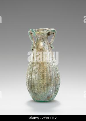 Korb Amphoriskos, 1. Jahrhundert n. Chr. zusätzliche Info: Dieser mold mundgeblasene Korb Amphoriskos besteht aus blassblauem Glas (erscheint in etwas Licht grün). Sein tropfenförmiger Körper mit flacher Basis ist mit einem Korbmuster verziert. Die Nahtmarkierung zeigt an, dass diese Amphoriskos in einer zweiteiligen Form eingeblasen wurden. Der kurze zylindrische Hals endet mit einem sich abflackernden Mund und nach innen gefalteter Lippe. Zwei kleine „schwimmende“ Griffe wurden an der Felge angebracht. Die Oberfläche ist innen schillernd und zeigt einige bräunliche akkretionen um die Griffe herum. Stockfoto