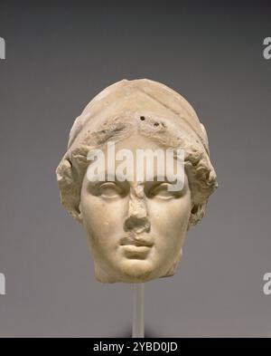 Leiter der Minerva, A.D. 1-50. Zusätzliche Info: Dieser Helmkopf ist alles, was von einer überlebensgroßen Statue einer weiblichen Figur übrig geblieben ist. Ein Großteil des Helmwappens ist abgebrochen und die Vorderkante des Helms wurde neu geschnitten. Eine Reihe kleiner Löcher wurde in die Haarlinie gebohrt, um Teile (die jetzt fehlen) hinzuzufügen, um beschädigte Bereiche zu ersetzen. In einigen Löchern hinterlassene eiserne Dübel deuten darauf hin, dass diese Reparatur in späthellenistischer oder römischer Zeit vorgenommen wurde. Der Helm bedeckt den größten Teil des Kopfes, aber gewelltes Haar ragt über den gesamten Rand hinaus. Während das Fleisch der Figur’auf eine matte Oberfläche poliert wurde, wurde das h Stockfoto