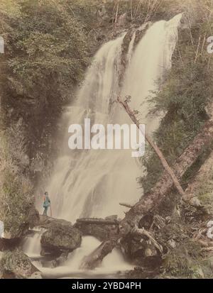 Gehino Taki (Wasserfall) in Nikko, 1870er-1890er Jahre Ein Mann am Fuße eines Wasserfalls, umgeben von üppiger Vegetation, bekannt als Kegon Waterfall (Kegon no taki). Stockfoto