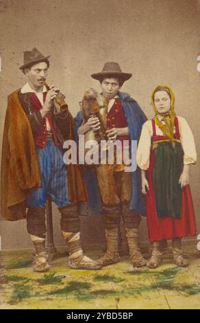 Drei italienische Bauern stehen: Zwei Männer spielen Bläser, ein Mädchen daneben, 1865-1875. Stockfoto