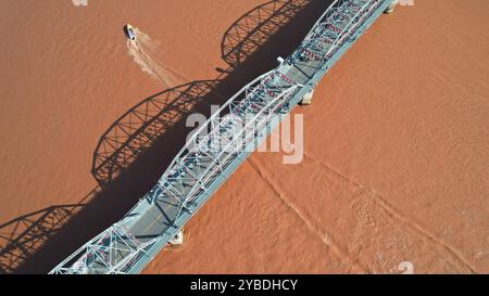 (241018) -- LANZHOU, 18. Oktober 2024 (Xinhua) -- ein Luftdrohnenfoto vom 23. September 2024 zeigt ein Schnellboot, das über die Zhongshan-Brücke des Gelben Flusses in Lanzhou, Nordwestchinas Provinz Gansu, segelt. Lanzhou, einst Verkehrsknotenpunkt, Militärfestung und wichtiges Handelsgebiet entlang der alten Seidenstraße, ist die einzige Provinzhauptstadt, durch die der gelbe Fluss fließt. Der Abschnitt Lanzhou des Hauptstroms des Gelben Flusses ist 150,7 Kilometer lang, davon 47,5 Kilometer durch das Stadtgebiet. Der gelbe Fluss ist auch eine wichtige Trinkwasserquelle Stockfoto