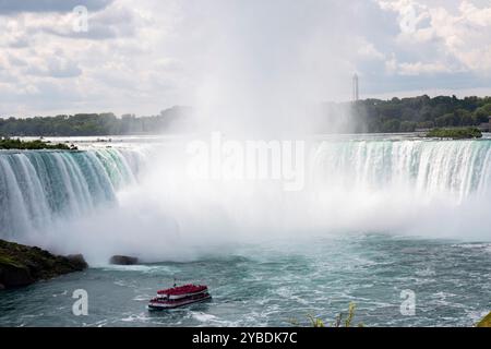 Ein Boot navigiert durch die Gewässer in der Nähe der Niagarafälle Horseshoe Falls. Stockfoto