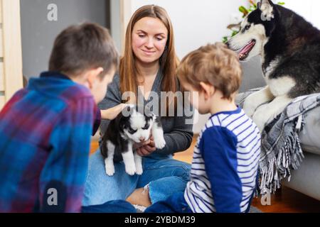 Kinder und Mutter mit Welpen drinnen Stockfoto