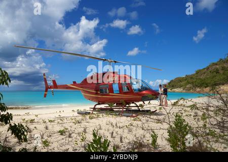 Bell LongRanger Hubschrauber an einem Sandstrand auf der Insel Antigua in der Karibik. Stockfoto