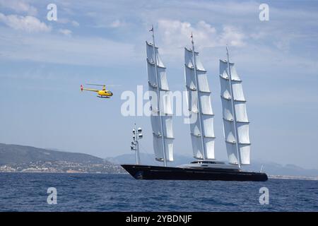 88 m lange Superyacht Maltese Falke segelt in einer Regatta, mit einem Robinson 44 Hubschrauber, der Videos und Fotos macht. Stockfoto