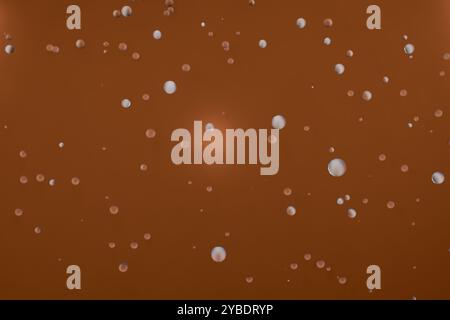 Abstraktes Bild mit schwimmenden Blasen auf warmbraunem Karamellhintergrund. 3D-Rendering Stockfoto